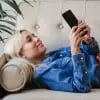 Woman lying on couch while she accesses digital banking through her smartphone