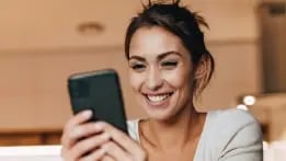 Woman using her cell phone to set up her debit Card Controls