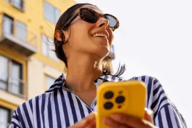 Woman gets an alert on her cell phone that her paycheck has been deposited two days early via Early Pay