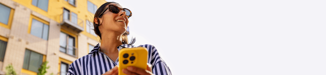 Woman enjoying her day as she checks her checking balance in the Hancock Whitney mobile app