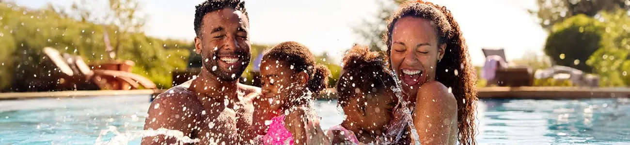 Family celebrating in the pool after getting approved for a HELOC